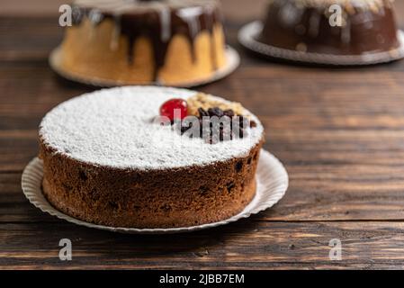 Torte varie su sfondo o tavolo di legno. Assortimento di torte per feste. Foto Stock