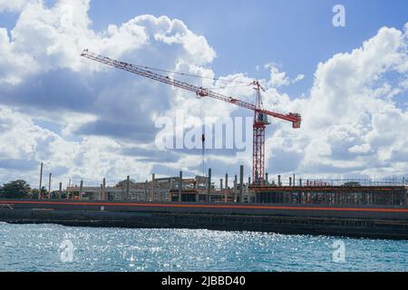 Costruzione di edifici a più piani. Costruzione gru su sfondo blu cielo. Edifici alti e moderni in costruzione. Costruzione su Foto Stock