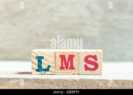 Blocco di lettere alfabetiche in parola LMS (abbreviazione del sistema di gestione dell'apprendimento) su sfondo di legno Foto Stock