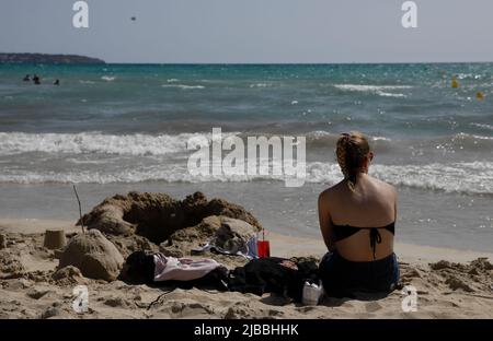 Palma, Spagna. 28th maggio 2022. Una donna si rilassa sulla spiaggia di Arenal. A Maiorca sembra quasi che non ci sia mai stato un arresto di Corona. (A dpa 'perché la trasformazione dell'immagine di Maiorca è fallita per il momento') Credit: Clara Margais/dpa/Alamy Live News Foto Stock