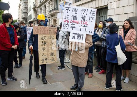 I manifestanti hanno cartelloni che esprimono la loro opinione durante la manifestazione presso l'Ambasciata cinese. La forza congiunta di Hongkongers, tibetani e uiguri tiene una veglia a lume di candela fuori dall'ambasciata cinese a Londra nel 33rd anniversario del massacro di Piazza Tiananmen. Il 4th giugno 1989, truppe cinesi armate di fucili d'assalto e accompagnate da carri armati sparati ai manifestanti studenti e a coloro che stavano cercando di bloccare l'avanzamento dei militari in Piazza Tiananmen. A partire da oggi, il governo cinese nega ancora che l’incidente sia accaduto. Foto Stock
