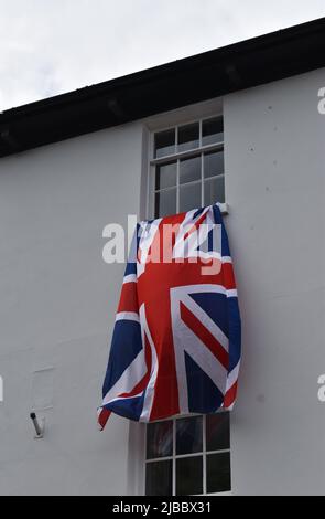 Union Jack vola da una finestra durante le celebrazioni per il Giubileo del platino della Regina. Foto Stock