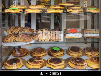 Una selezione di prodotti di pasticceria tra cui Crostata, strudel, Pizza Ebraica e torta ricotta e Visciole. Nella finestra della Pasticceria il Boccione Foto Stock