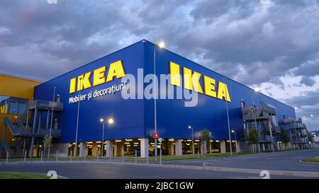 Logo IKEA su edificio, in tarda serata, con le nubi drammatiche. IKEA è un rivenditore di mobili pronti per l'assemblaggio, fondato in Svezia. Bucharest, Romania - Foto Stock