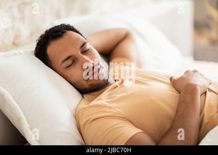 Guy Arabo dorme riposando con gli occhi chiusi in camera da letto Foto Stock