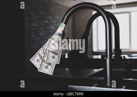Tocca con i dollari che ne fuoriescono. Approvvigionamento di acqua costoso. Il concetto di aumentare il prezzo dei servizi pubblici per la popolazione. Caldo costoso Foto Stock