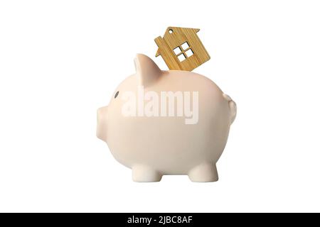 Piggy bank e casa chiave isolato su sfondo bianco. Il concetto di risparmio in su per il vostro bene immobile. Risparmia sul noleggio. Foto Stock