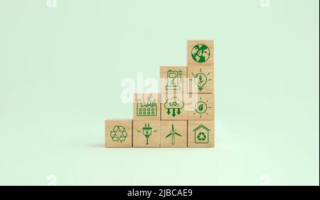 Simboli ecologici a impronta di carbonio su un cubo di legno. Energie alternative per salvare il pianeta. Concetto ambientale, cambiamento climatico. 3D rendering. Foto Stock