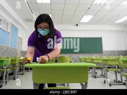 Pechino, Cina. 5th giugno 2022. Un membro dello staff incolla i numeri sulle scrivanie in un sito di esame del prossimo esame di ingresso al college nazionale per il 2022 a Pechino, capitale della Cina, il 5 giugno 2022. Un nuovo apogeo di 11,93 milioni di studenti parteciperà all'esame di ingresso del college nazionale cinese per il 2022, noto anche come "gaokao". Credit: Ren Chao/Xinhua/Alamy Live News Foto Stock