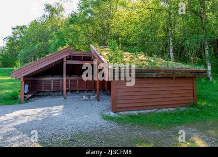 Un rifugio coperto dal tetto con un circolo di falò nel mezzo nel parco del lago Halandsvatnet, Stavanger, Norvegia, maggio 2018 Foto Stock