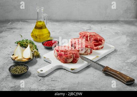 Il lombo di agnello crudo non cotti le bistecche della sella sul tagliere di legno Foto Stock