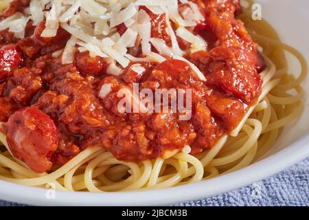 Sphaghetti alla filapina con fettine di hot dog e salsa di banana con parmigiano grattugiato Foto Stock