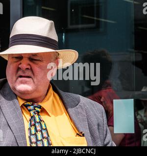 Epsom Surrey, Londra UK, Giugno 04 2022, Senior Man Wering Orange Shirt Tie e Panama Hat Looking Grumpy Foto Stock