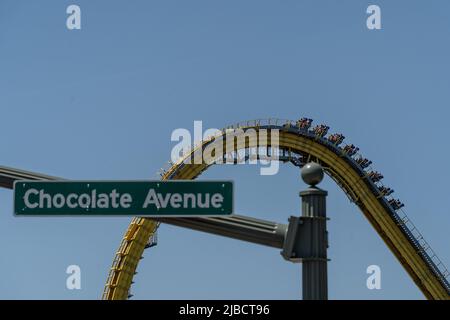 Hershey Pennsylvania, 30 maggio 2022: Chocolate Avenue segnaletica stradale con Hersheypark montagne russe sullo sfondo. Foto Stock