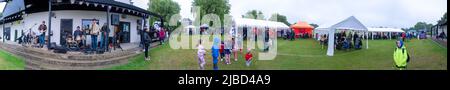 Willingham Cambridgeshire, Regno Unito. 5th giugno 2022. La gente festeggia il fine settimana del Giubileo del platino della Regina sotto la pioggia in un picnic sul terreno ricreativo. Molta gente era determinata a celebrare l'occasione nonostante la pioggia gocciolante, portando i propri picnic e godendo di una band blues, bancarelle di cibo, bar e giochi. Credit: Julian Eales/Alamy Live News Foto Stock