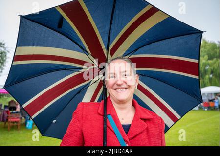 Willingham Cambridgeshire, Regno Unito. 5th giugno 2022. La gente festeggia il fine settimana del Giubileo del platino della Regina sotto la pioggia in un picnic sul terreno ricreativo. Molta gente era determinata a celebrare l'occasione nonostante la pioggia gocciolante, portando i propri picnic e godendo di una band blues, bancarelle di cibo, bar e giochi. Credit: Julian Eales/Alamy Live News Foto Stock