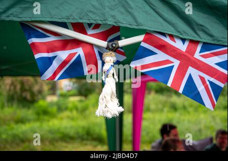 Willingham Cambridgeshire, Regno Unito. 5th giugno 2022. La gente festeggia il fine settimana del Giubileo del platino della Regina sotto la pioggia in un picnic sul terreno ricreativo. Molta gente era determinata a celebrare l'occasione nonostante la pioggia gocciolante, portando i propri picnic e godendo di una band blues, bancarelle di cibo, bar e giochi. Credit: Julian Eales/Alamy Live News Foto Stock
