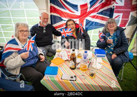 Willingham Cambridgeshire, Regno Unito. 5th giugno 2022. La gente festeggia il fine settimana del Giubileo del platino della Regina sotto la pioggia in un picnic sul terreno ricreativo. Molta gente era determinata a celebrare l'occasione nonostante la pioggia gocciolante, portando i propri picnic e godendo di una band blues, bancarelle di cibo, bar e giochi. Credit: Julian Eales/Alamy Live News Foto Stock