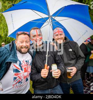 Willingham Cambridgeshire, Regno Unito. 5th giugno 2022. La gente festeggia il fine settimana del Giubileo del platino della Regina sotto la pioggia in un picnic sul terreno ricreativo. Molta gente era determinata a celebrare l'occasione nonostante la pioggia gocciolante, portando i propri picnic e godendo di una band blues, bancarelle di cibo, bar e giochi. Credit: Julian Eales/Alamy Live News Foto Stock