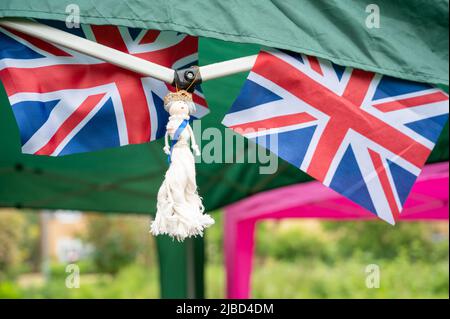 Willingham Cambridgeshire, Regno Unito. 5th giugno 2022. La gente festeggia il fine settimana del Giubileo del platino della Regina sotto la pioggia in un picnic sul terreno ricreativo. Molta gente era determinata a celebrare l'occasione nonostante la pioggia gocciolante, portando i propri picnic e godendo di una band blues, bancarelle di cibo, bar e giochi. Credit: Julian Eales/Alamy Live News Foto Stock
