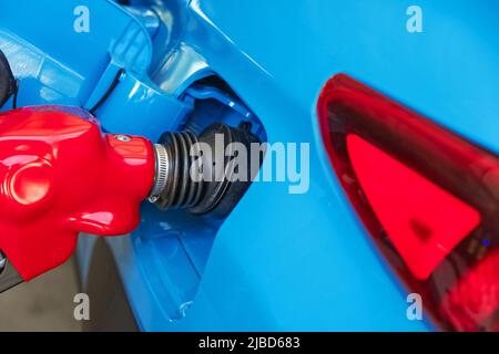 Rifornimento di auto blu su una stazione di servizio, lancia in un primo piano del serbatoio. Concetto di aumento dei prezzi del gas Foto Stock