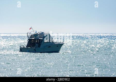 Una barca a noleggio per la pesca si dirige verso il lago Michigan in una mattinata estiva fredda vicino a Port Washington, Wisconsin. Foto Stock