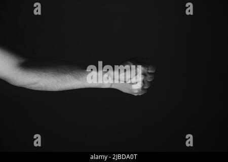 Brutale mano di uomo con vene sporgenti, sfondo nero.foto in bianco e nero Foto Stock