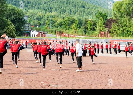 I discepoli del Tempio Shaoling di Henan praticano i loro esercizi di kungfu in uno dei campi di allenamento del tempio. Foto Stock