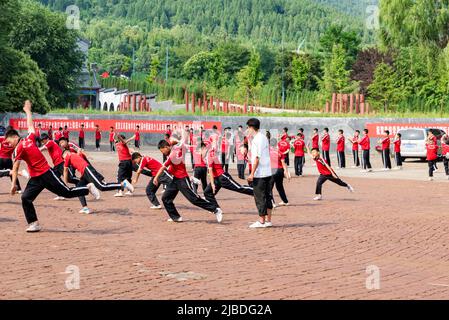 I discepoli del Tempio Shaoling di Henan praticano i loro esercizi di kungfu in uno dei campi di allenamento del tempio. Foto Stock