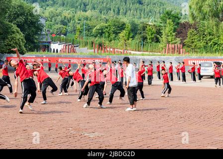 I discepoli del Tempio Shaoling di Henan praticano i loro esercizi di kungfu in uno dei campi di allenamento del tempio. Foto Stock