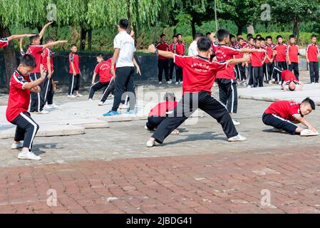 I discepoli del Tempio Shaoling di Henan praticano i loro esercizi di kungfu in uno dei campi di allenamento del tempio. Foto Stock