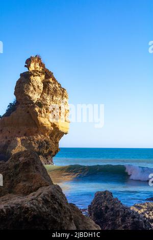 Costa dell'Algarve a Faro Portogallo con scogliere e onde che si infrangono sullo sfondo. Foto Stock