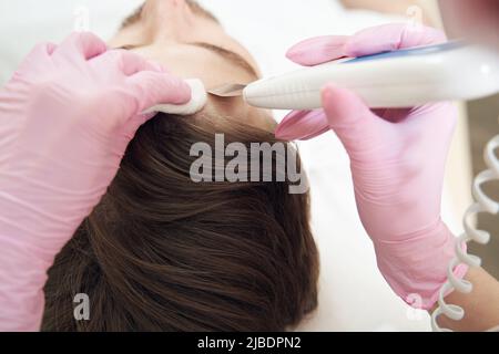 Trattamento della pelle della fronte con scrubber ultrasonico della pelle Foto Stock