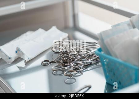 Strumenti chirurgici come le pinze disposte sul tavolo per l'intervento chirurgico Foto Stock