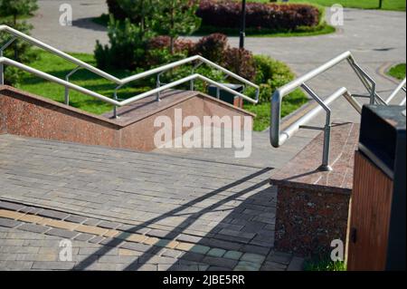 scale con ringhiere in acciaio sulla strada, la direzione del movimento è verso il basso Foto Stock