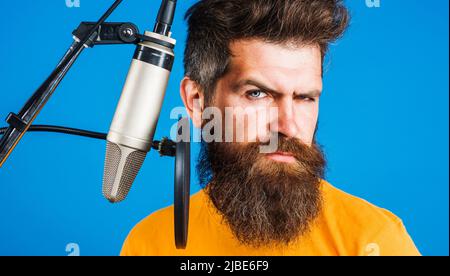 Canto in studio. Karaoke uomo. Voce professionale maschile che canta nel microfono a condensatore. Foto Stock