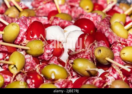antipasti con salsiccia, olive e mozzarella sugli spiedini. Buffet con tartine e antipasti su spiedini di legno. Salsiccia, olive, mozzarella di se Foto Stock