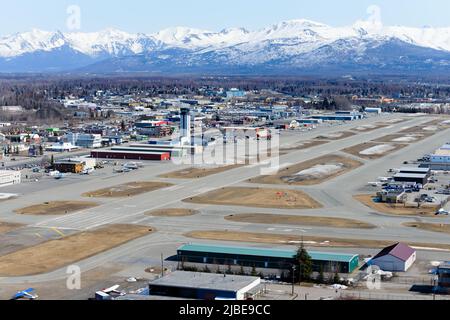 Aeroporto Merrill Field di Anchorage, utilizzato principalmente per l'aviazione generale. Pista di Merrill Field con montagne alle spalle. Foto Stock