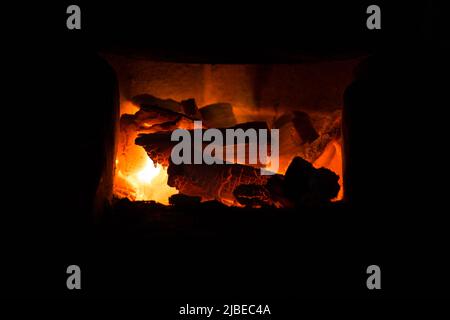 Il fuoco e la brace nel caminetto in mattoni forno Foto Stock