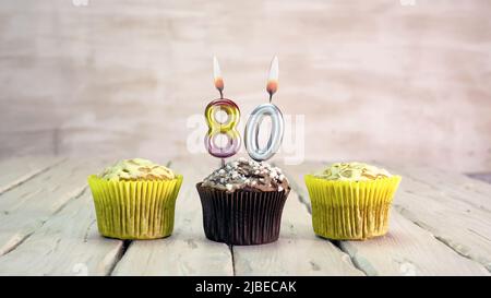 Buon compleanno muffin con candele con il numero. Spazio per la copia della scheda con torte per Complimenti. Foto Stock