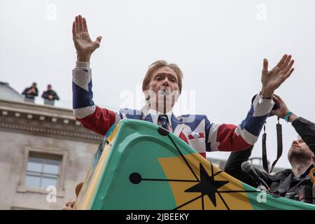Londra, Regno Unito. 5th giugno 2022. Sir Cliff Richard ondeggia dalla cima di un autobus a due piani per celebrare il 1950s come parte del Platinum Jubilee Pageant che si tiene nel centro di Londra per segnare i 70 anni di sua Maestà sul trono. La sfilata del 3km è condotta dalla vettura di stato d'oro, una carrozza di 260 anni che portò la Regina da e per la sua incoronazione nel 1953. Credit: Kiki Streitberger / Alamy Live News Foto Stock