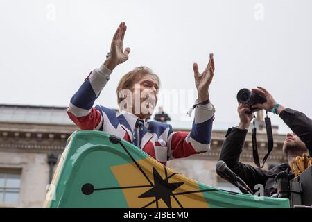Londra, Regno Unito. 5th giugno 2022. Sir Cliff Richard ondeggia dalla cima di un autobus a due piani per celebrare il 1950s come parte del Platinum Jubilee Pageant che si tiene nel centro di Londra per segnare i 70 anni di sua Maestà sul trono. La sfilata del 3km è condotta dalla vettura di stato d'oro, una carrozza di 260 anni che portò la Regina da e per la sua incoronazione nel 1953. Credit: Kiki Streitberger / Alamy Live News Foto Stock