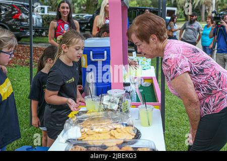 St. Petersburg, FL. USA; la presidente e sopravvissuta al cancro pediatrico Caroline Gallagher mostra tutti i dolcetti disponibili a un partecipante che partecipa a una raccolta fondi il 4 giugno 2022. C&C Lemonade Factory Lemonade Stand è stato avviato sei anni fa per raccogliere fondi e sensibilizzare per la ricerca pediatrica sul cancro. Tutti i fondi raccolti vanno al Johns Hopkins All Children's Hospital e alla Alex's Lemonade Stand Foundation. (Kim Hukari/immagine dello sport) Foto Stock