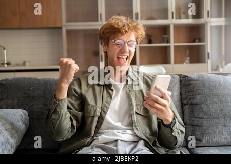 Eccitato giovane zenzero irlandese gesturing sì alla webcam mobile Foto Stock
