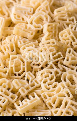 primo piano macro vista di lettere di pasta o alfabeto, sfondo full frame, dieta e concetto di cibo, preso in profondità di campo poco profondo Foto Stock