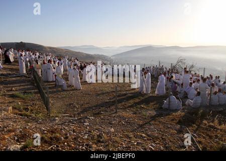 Nablus, Palestina. 27th maggio 2022. I membri dell'antica comunità samaritana pregano durante la vacanza di Shavuot sul monte Gerizim, vicino alla città di Nablus, in Cisgiordania. I Samaritani discesero dalle antiche tribù Israelite di Menashe ed Efraim ma si allontanarono dal giudaismo tradizionale 2.800 anni fa. Oggi, circa 700 dei restanti samaritani vivono nella città palestinese di Nablus in Cisgiordania e nella città israeliana di Holon, a sud di Tel Aviv. Credit: SOPA Images Limited/Alamy Live News Foto Stock