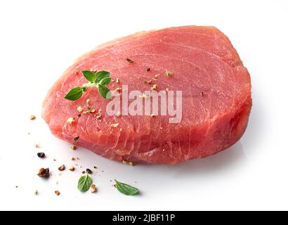 bistecca di tonno fresco crudo con erbe e spezie isolate su sfondo bianco Foto Stock