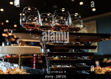 molti bicchieri con cognac, whiskey si trovano al bar. tanti bicchieri con cognac. bevande alcoliche Foto Stock