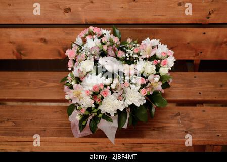 Bouquet di fiori a forma di cuore su sfondo ligneo, San valentino Foto Stock