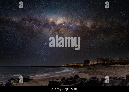 Località balneare tranquilla città di Pomorie con luci elettriche luminose e grandi e confortevoli hotel di lusso sullo sfondo di notte stellato blu cielo e ca Foto Stock